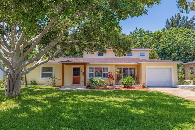 view of front of home with a front yard and a garage