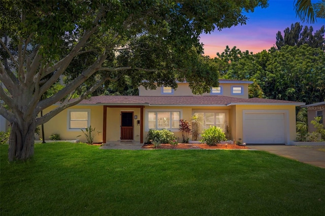 view of front of home with a garage and a yard