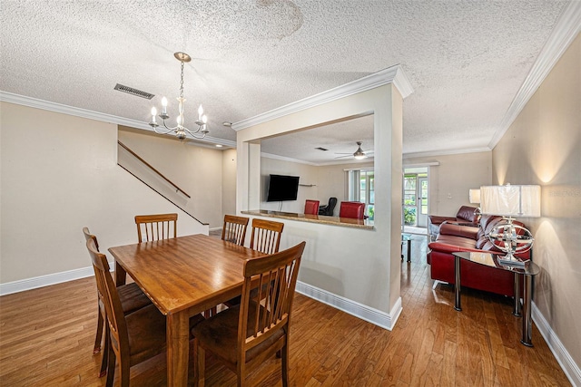 dining room featuring a textured ceiling, hardwood / wood-style floors, ceiling fan with notable chandelier, and ornamental molding