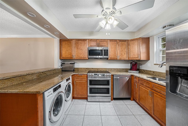 kitchen with sink, washer / dryer, stainless steel appliances, and stone counters