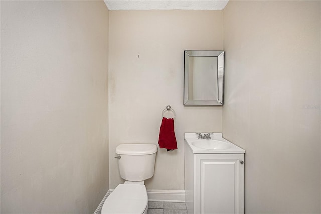 bathroom featuring tile patterned flooring, vanity, a textured ceiling, and toilet