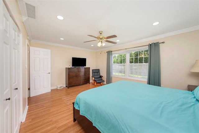 bedroom featuring ceiling fan, a closet, ornamental molding, and light hardwood / wood-style flooring