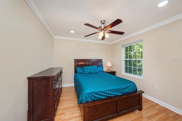 bedroom with ceiling fan, light hardwood / wood-style floors, a textured ceiling, and ornamental molding