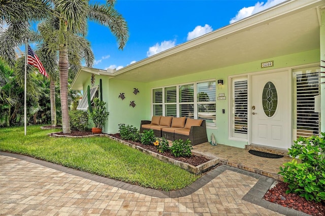 entrance to property featuring a yard and an outdoor hangout area