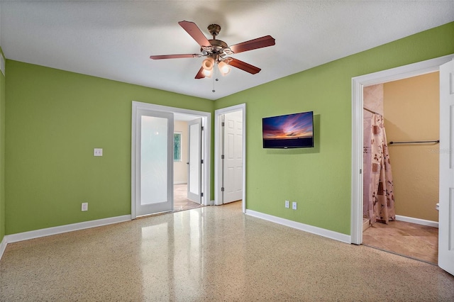 unfurnished bedroom with ceiling fan, french doors, and ensuite bathroom