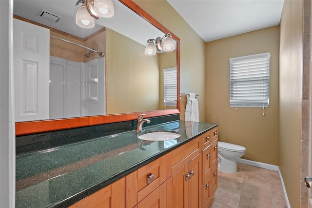 bathroom with tile patterned flooring, a shower, vanity, and toilet