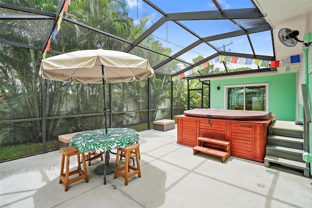 view of patio / terrace featuring glass enclosure and a hot tub