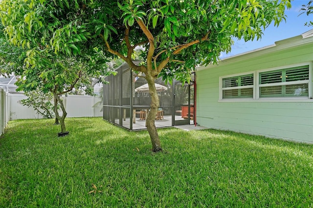 view of yard with glass enclosure and a patio area