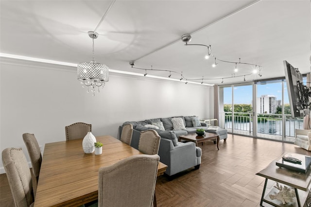 dining room with track lighting, a chandelier, and parquet flooring