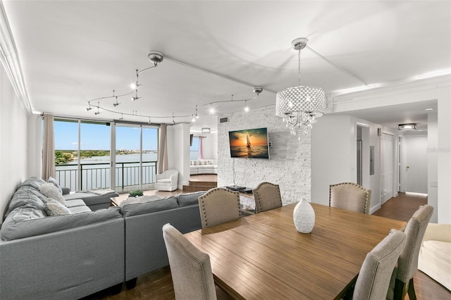 dining space with an inviting chandelier, rail lighting, dark hardwood / wood-style flooring, and ornamental molding