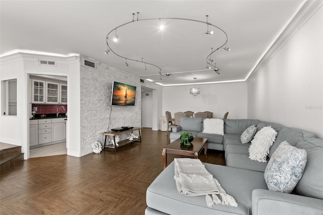 living room featuring crown molding and dark parquet flooring