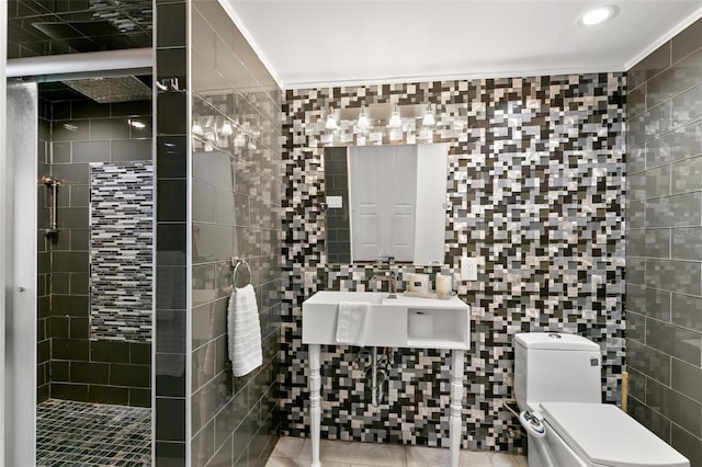 bathroom featuring ornamental molding, toilet, sink, and tile walls