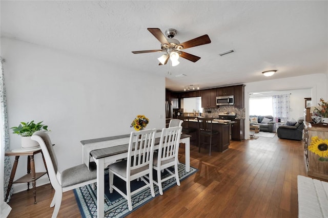 dining room featuring dark hardwood / wood-style floors, a textured ceiling, and ceiling fan