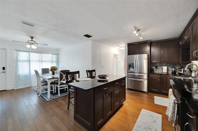 kitchen featuring sink, a kitchen island, stainless steel appliances, and hardwood / wood-style flooring