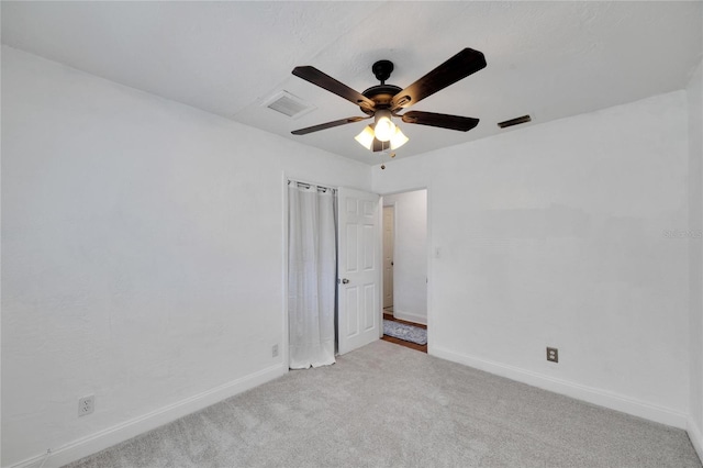 empty room with light colored carpet and ceiling fan