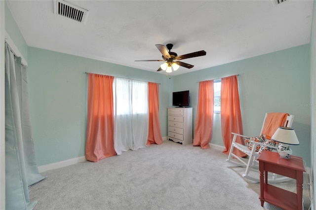 living area with light colored carpet and ceiling fan