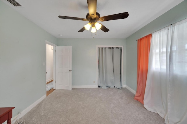 unfurnished bedroom featuring ceiling fan and light carpet