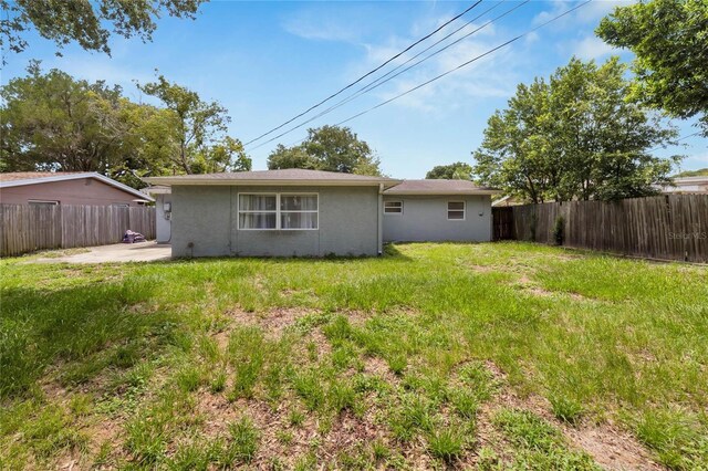 rear view of property featuring a patio and a lawn