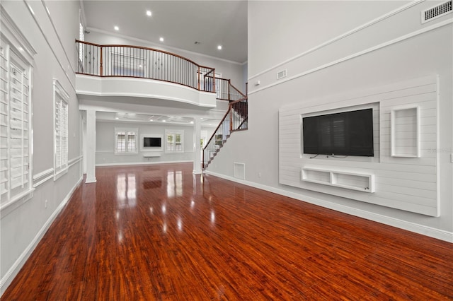 unfurnished living room with hardwood / wood-style floors and a high ceiling