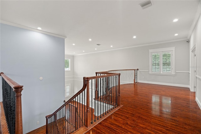 stairs with hardwood / wood-style floors, a wealth of natural light, and crown molding