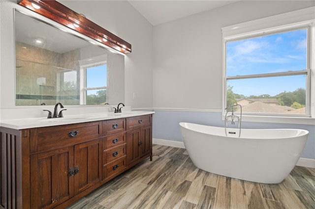 bathroom with hardwood / wood-style floors, vanity, shower with separate bathtub, and a wealth of natural light