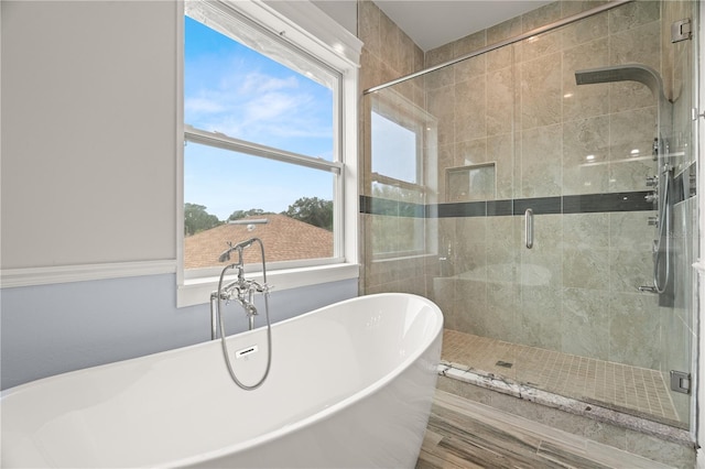 bathroom featuring shower with separate bathtub