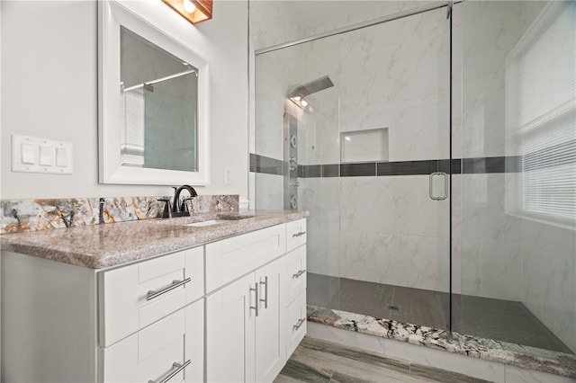 bathroom featuring vanity, wood-type flooring, and walk in shower