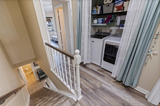 clothes washing area with hardwood / wood-style flooring and washing machine and clothes dryer