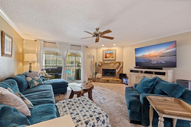 living room with ceiling fan, ornamental molding, light tile patterned flooring, and a textured ceiling