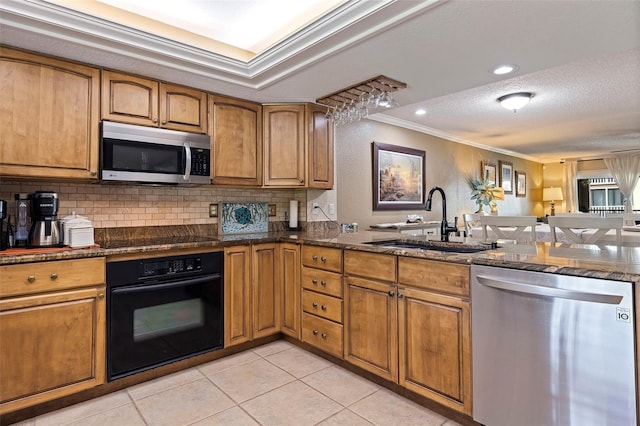 kitchen with dark stone counters, black appliances, crown molding, light tile patterned floors, and sink