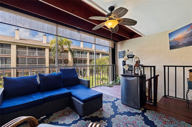 sunroom / solarium featuring ceiling fan and beamed ceiling