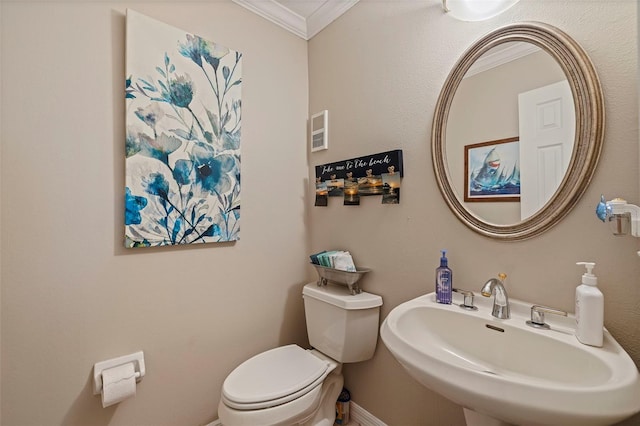 bathroom with toilet, sink, and ornamental molding