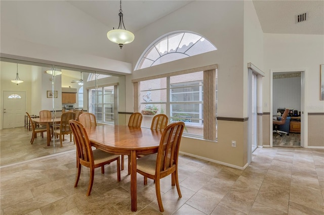 dining area with high vaulted ceiling