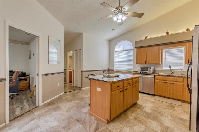 kitchen featuring a center island, a healthy amount of sunlight, lofted ceiling, and appliances with stainless steel finishes