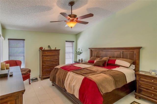 tiled bedroom featuring multiple windows, ceiling fan, and a textured ceiling