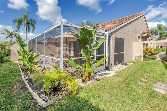 back of house featuring a yard and glass enclosure