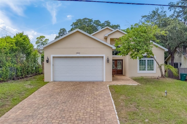 view of front of house with a garage, decorative driveway, a front yard, and stucco siding