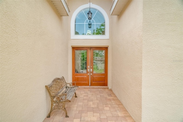 view of exterior entry featuring stucco siding and french doors