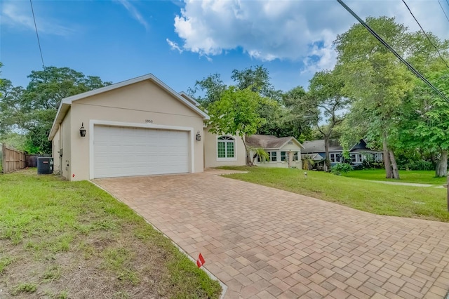 ranch-style house featuring a garage, central AC, and a front lawn