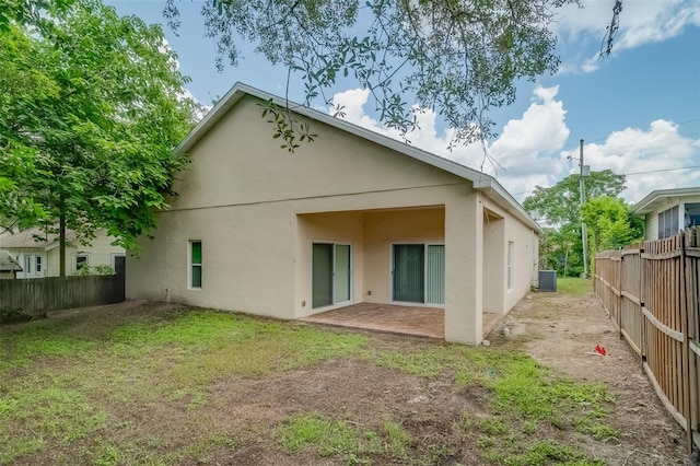 back of house with a patio and a lawn