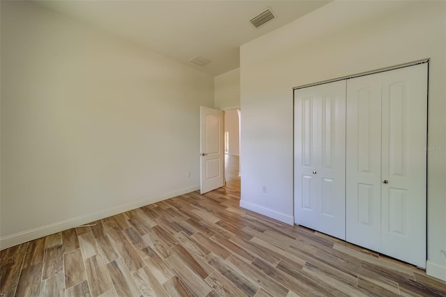 unfurnished bedroom featuring a closet and light wood-type flooring