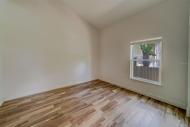 unfurnished room with lofted ceiling and light hardwood / wood-style floors