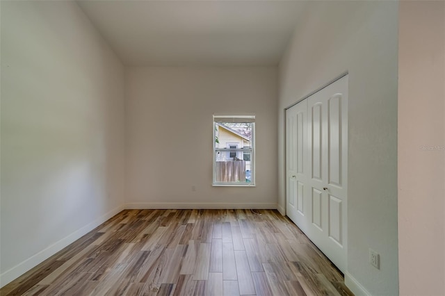 unfurnished bedroom featuring light hardwood / wood-style floors and a closet