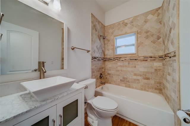 full bathroom with wood-type flooring, toilet, vanity, and tiled shower / bath