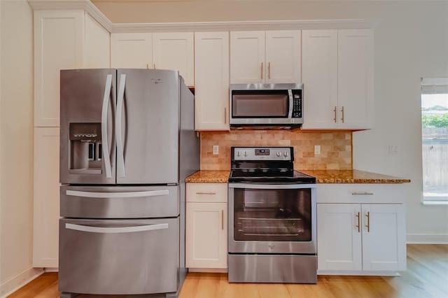 kitchen with white cabinets, stainless steel appliances, light hardwood / wood-style floors, and stone countertops