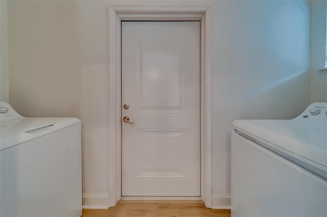 laundry room with light hardwood / wood-style floors and washing machine and clothes dryer