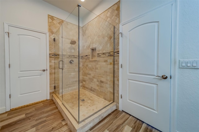 bathroom featuring a shower with door and wood-type flooring