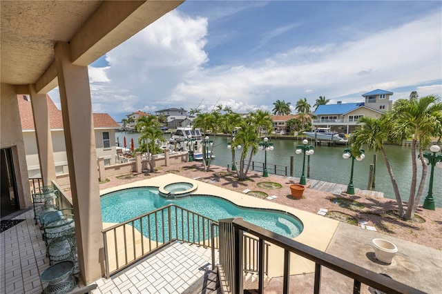 view of pool featuring an in ground hot tub, a water view, a dock, and a patio