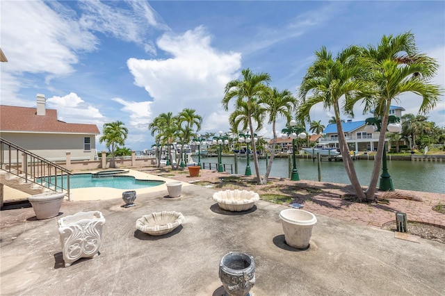 view of swimming pool with an in ground hot tub, a patio, and a water view