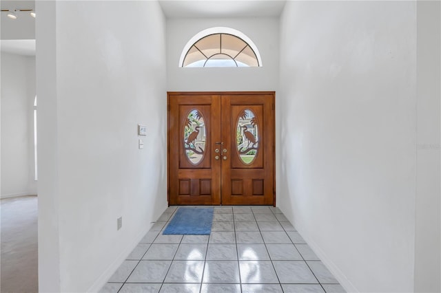 interior space with a high ceiling and light tile patterned flooring